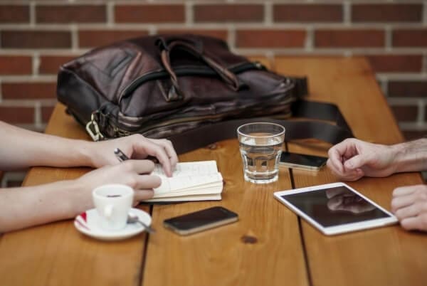 friends sitting in cafe writing in notebook with digital tablet and coffee cup 1