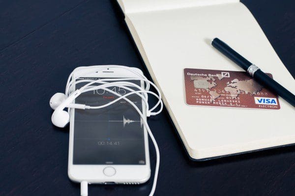 mobile phone and credit card with notebook and pen on table